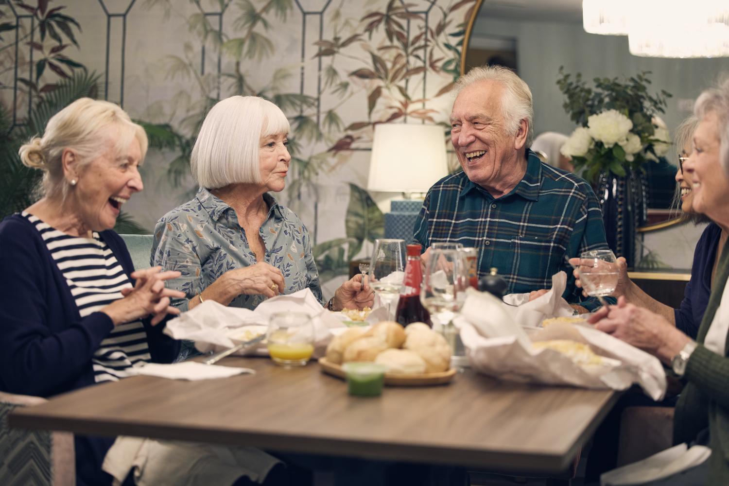a group of people sitting around a table with food
