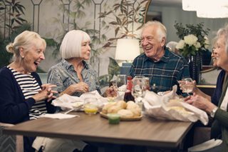 a group of people sitting around a table with food