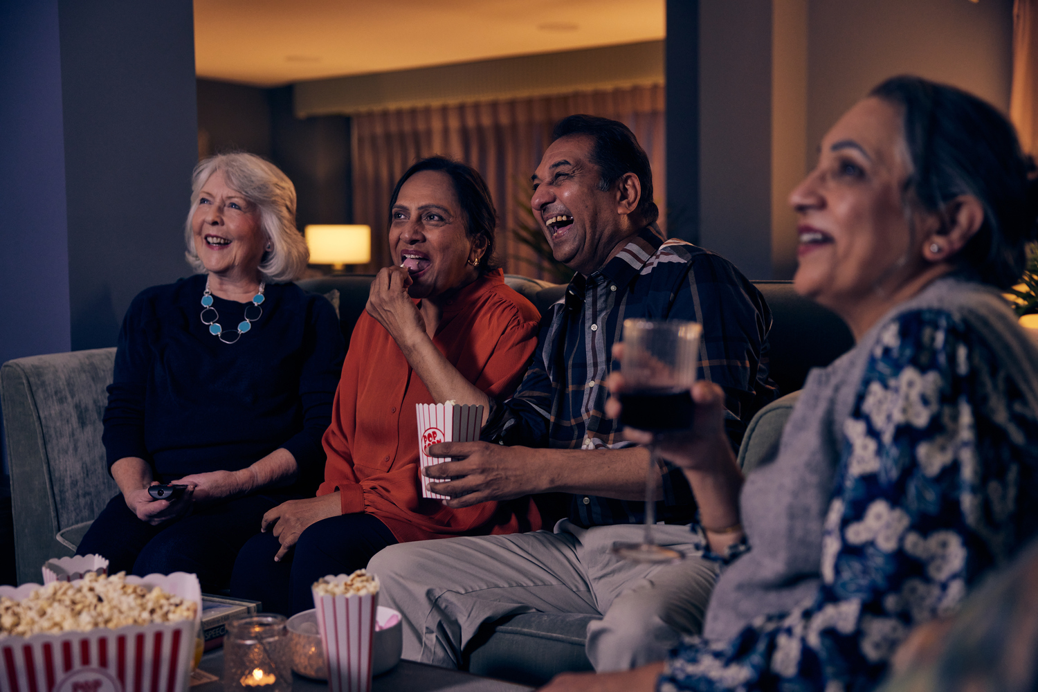 a group of people sitting on a couch and laughing
