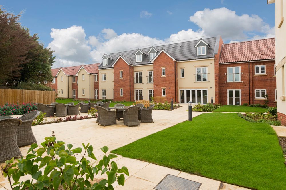 a brick building with a green lawn