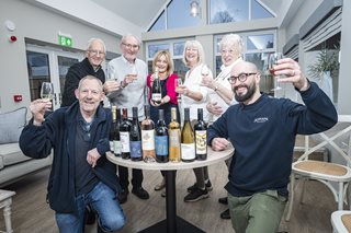 a group of people holding wine glasses