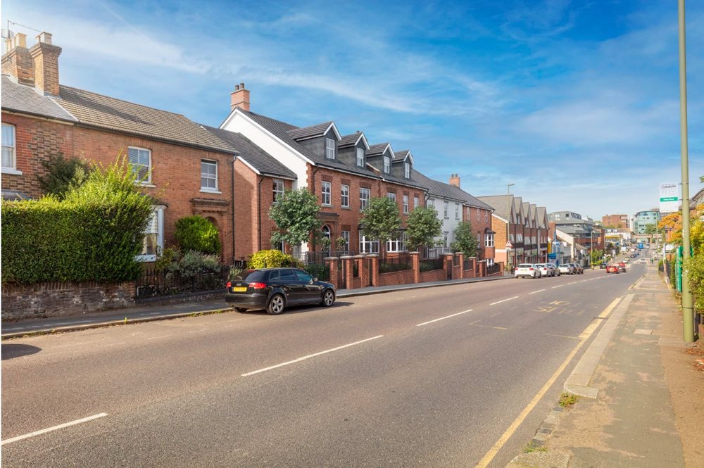 a street with cars and houses along it