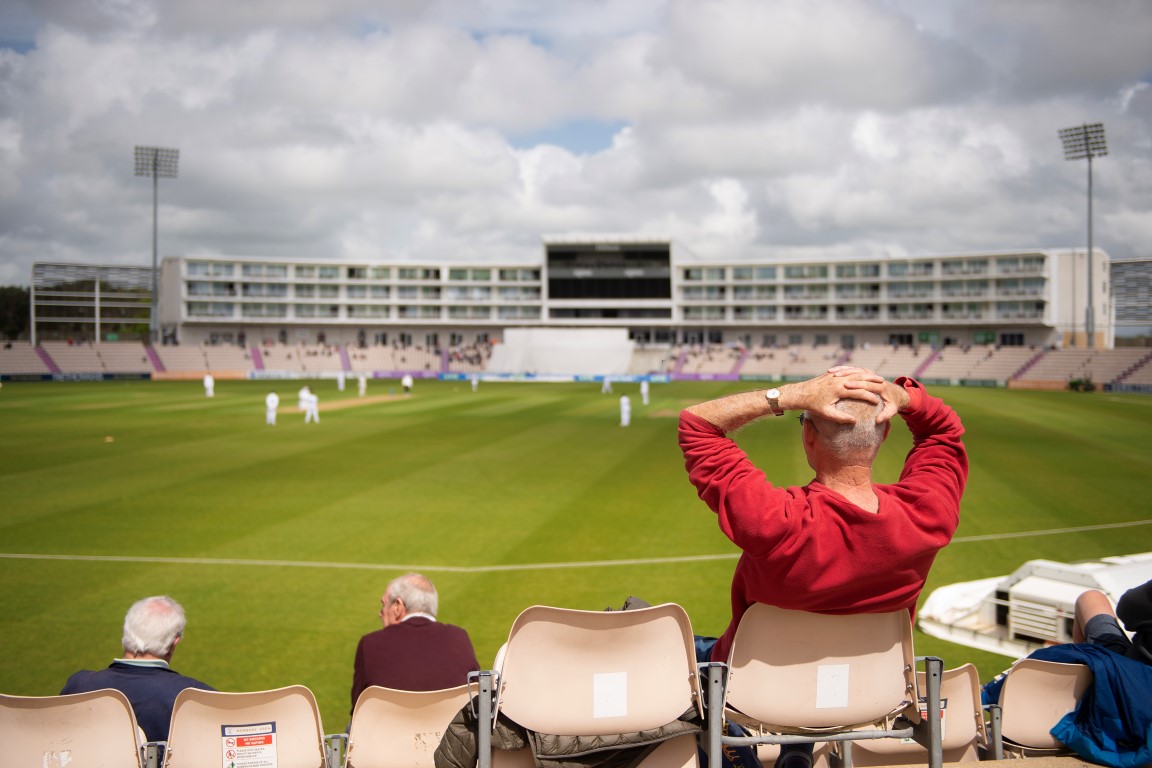 a person sitting in a stadium with the hands up