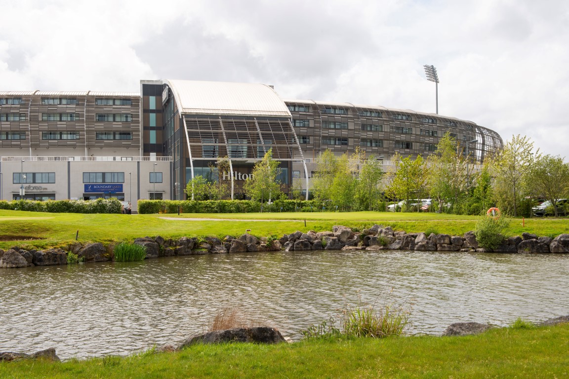 a large building with a pond in front of it