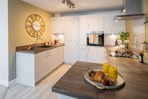 a kitchen with white cabinets and a table with food on it