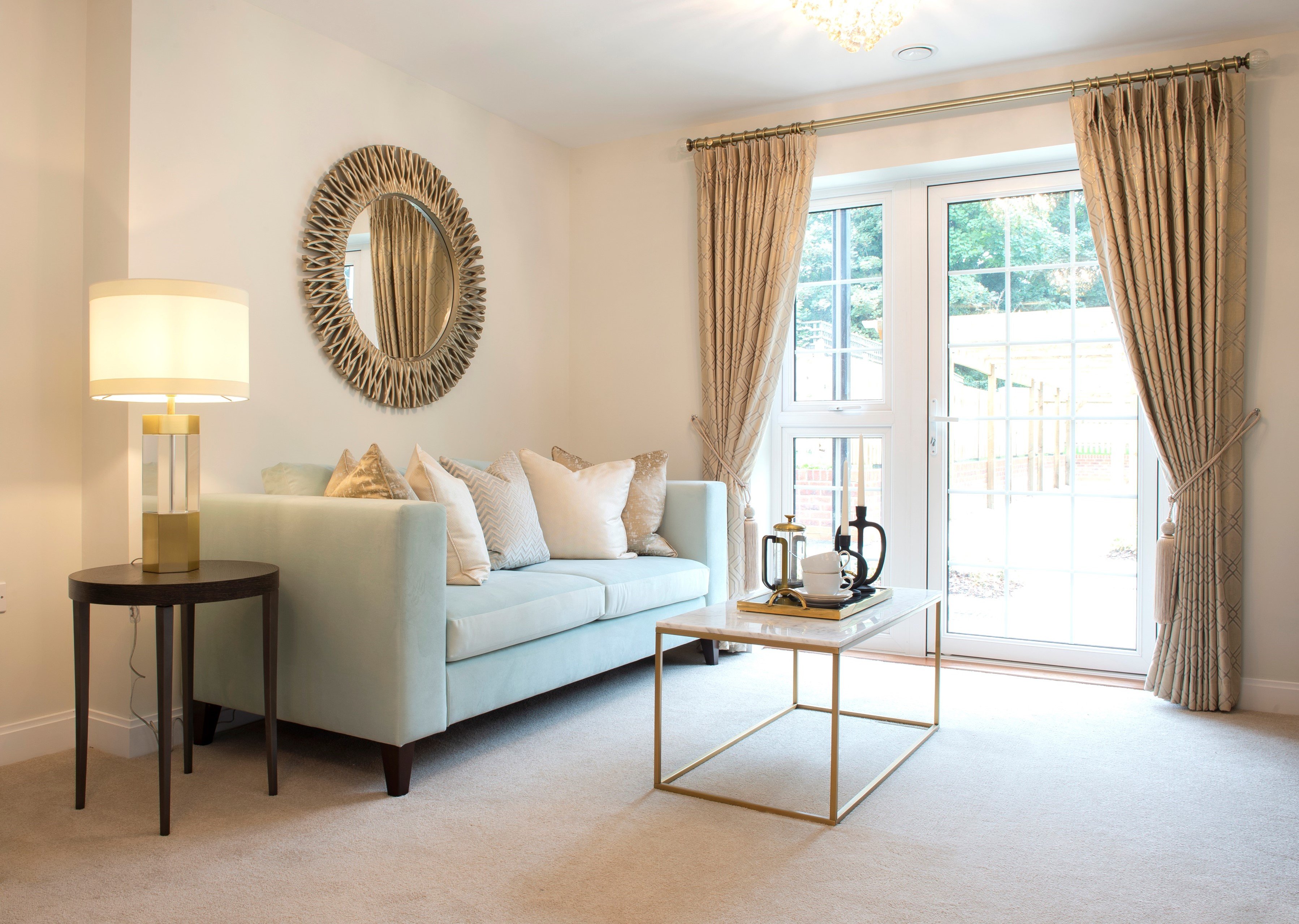 a living room with a white couch and a round mirror