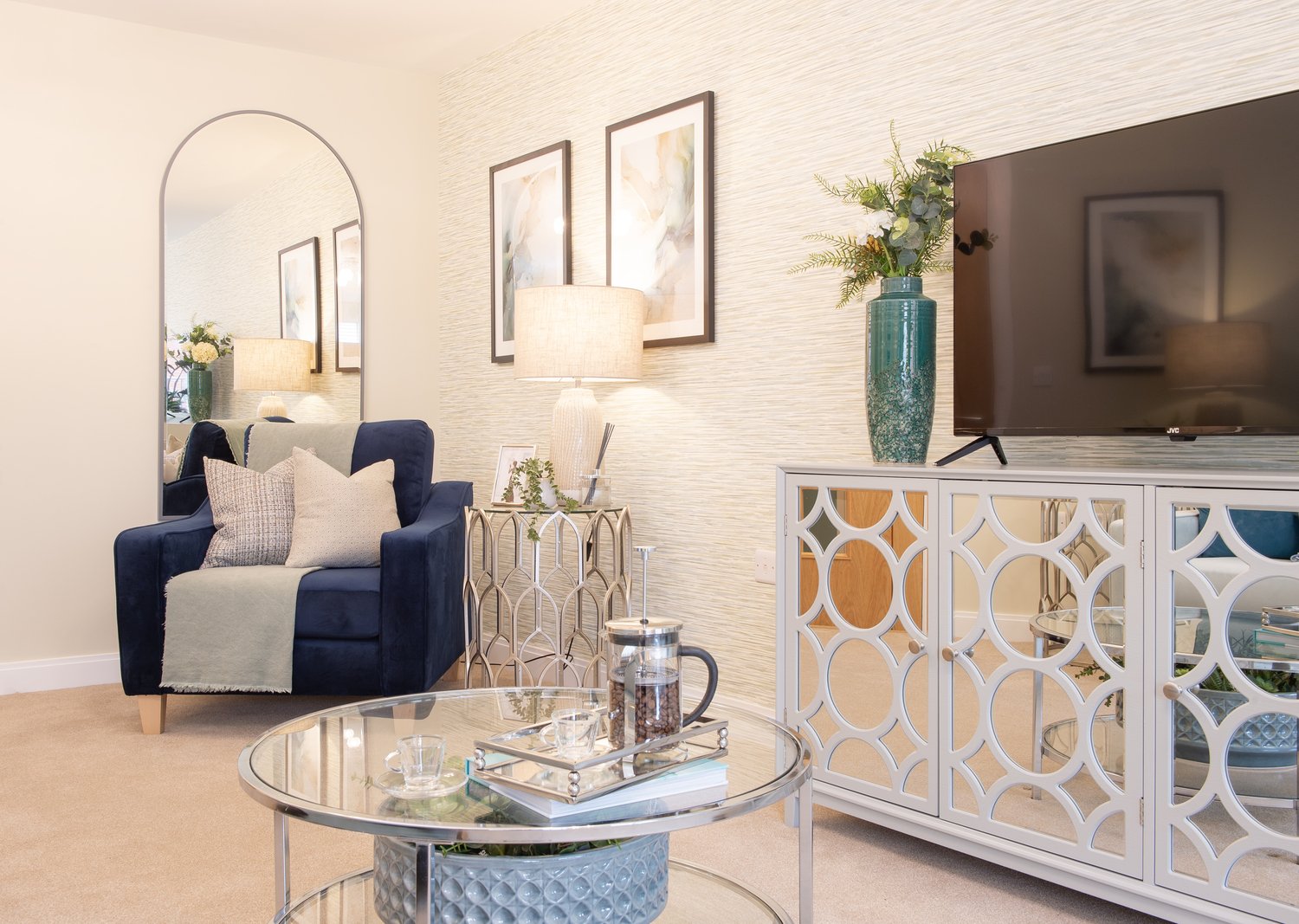 a living room with a glass coffee table and a chair