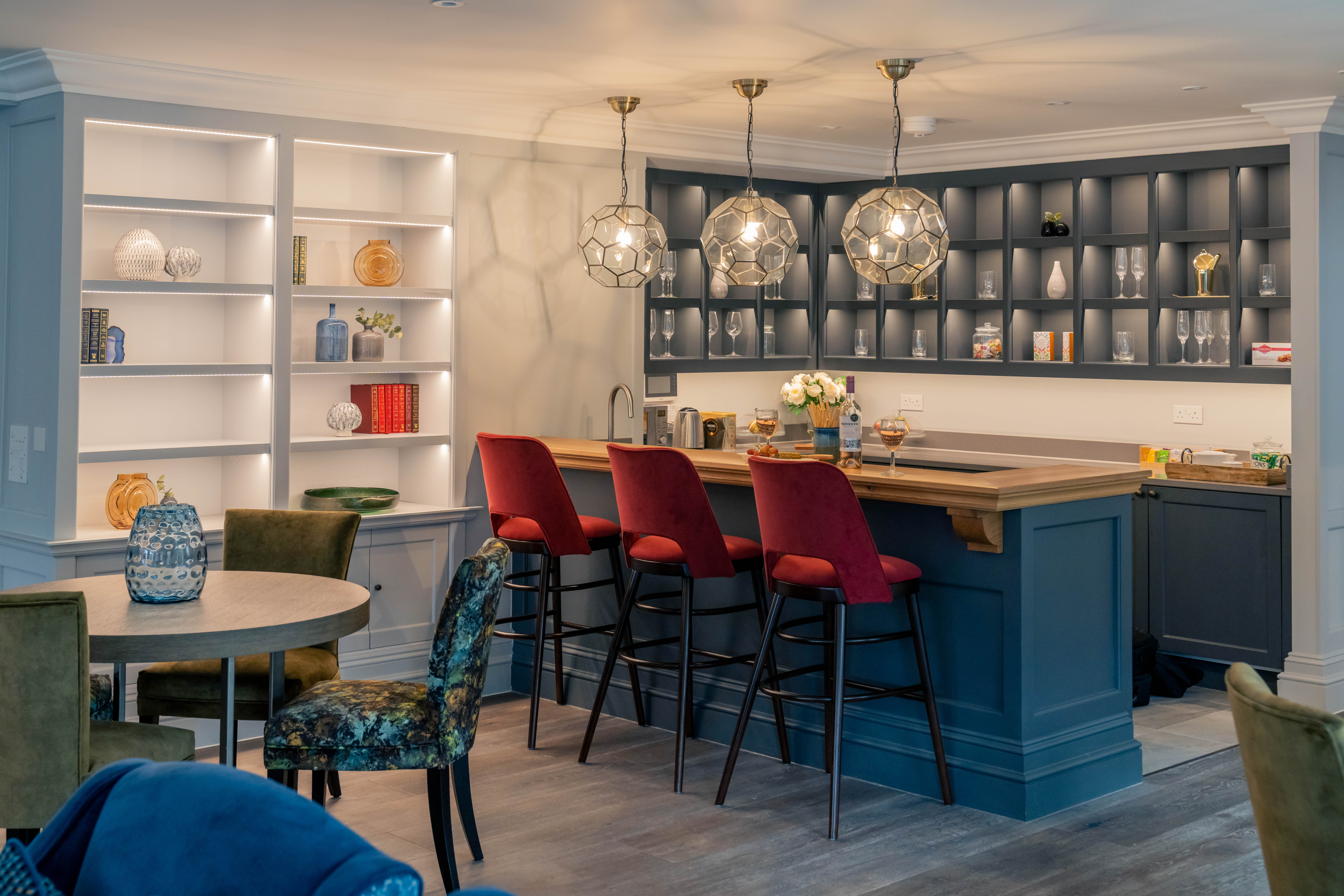a room with a table chairs and a shelf with lights