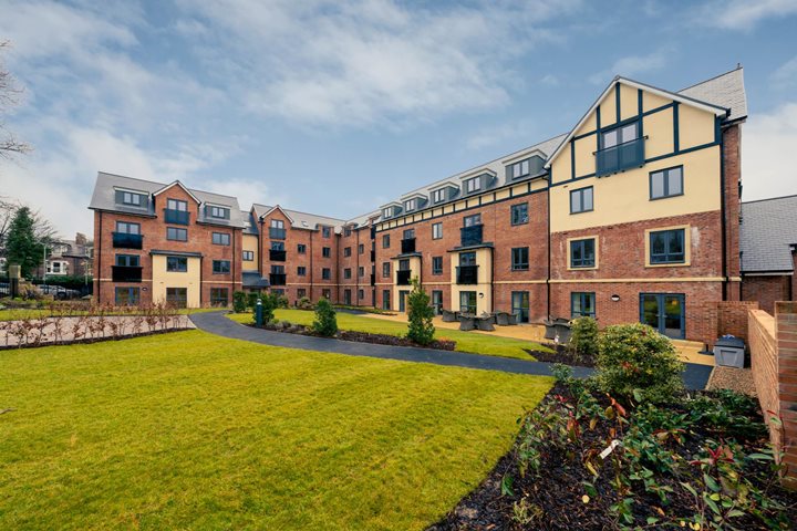 a building with a lawn and trees in front of it
