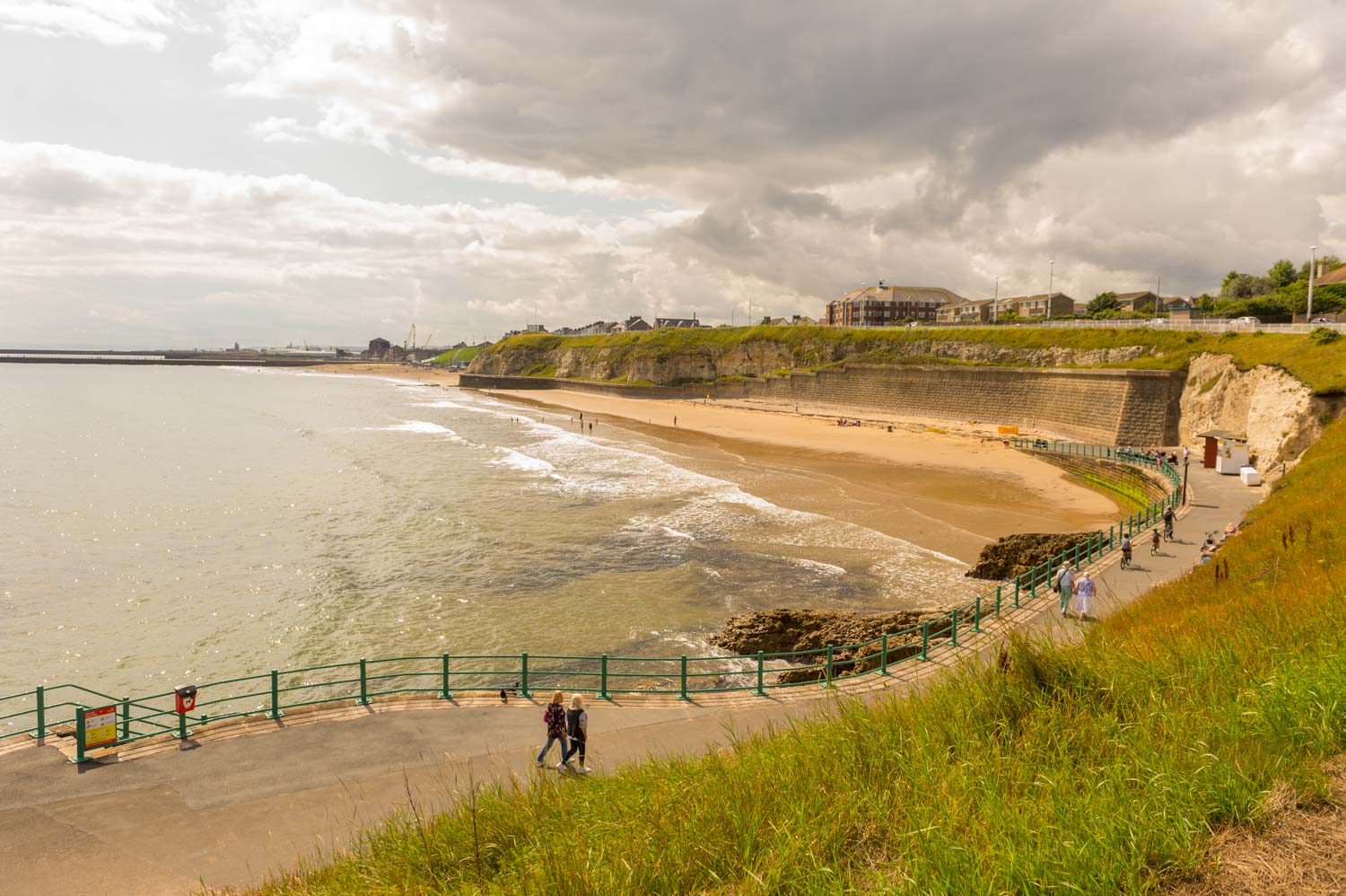 a beach with people walking on it