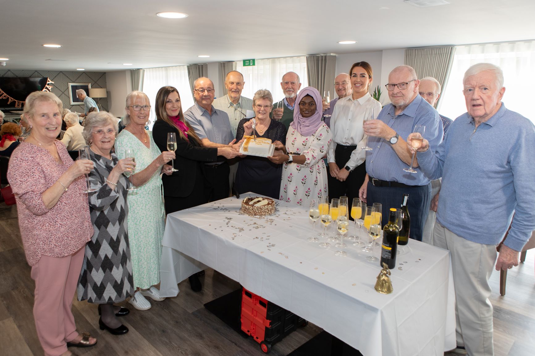 a group of people standing around a table with wine bottles