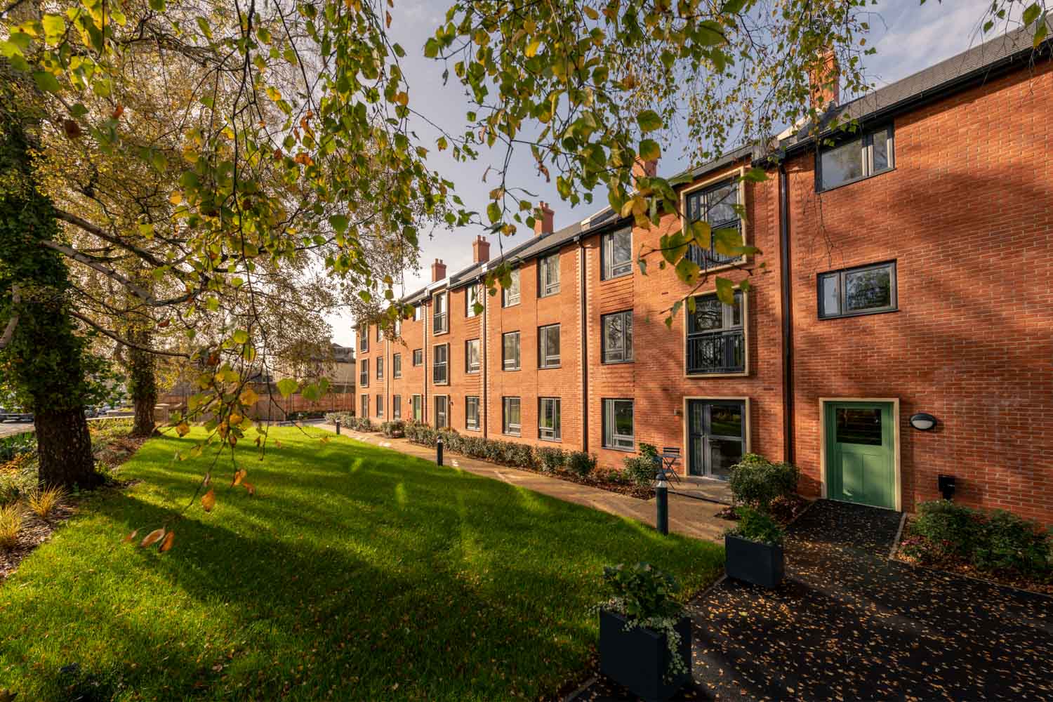 a brick building with trees and grass