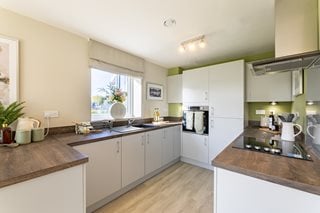 a fully fitted kitchen with white cabinets at Romeo place