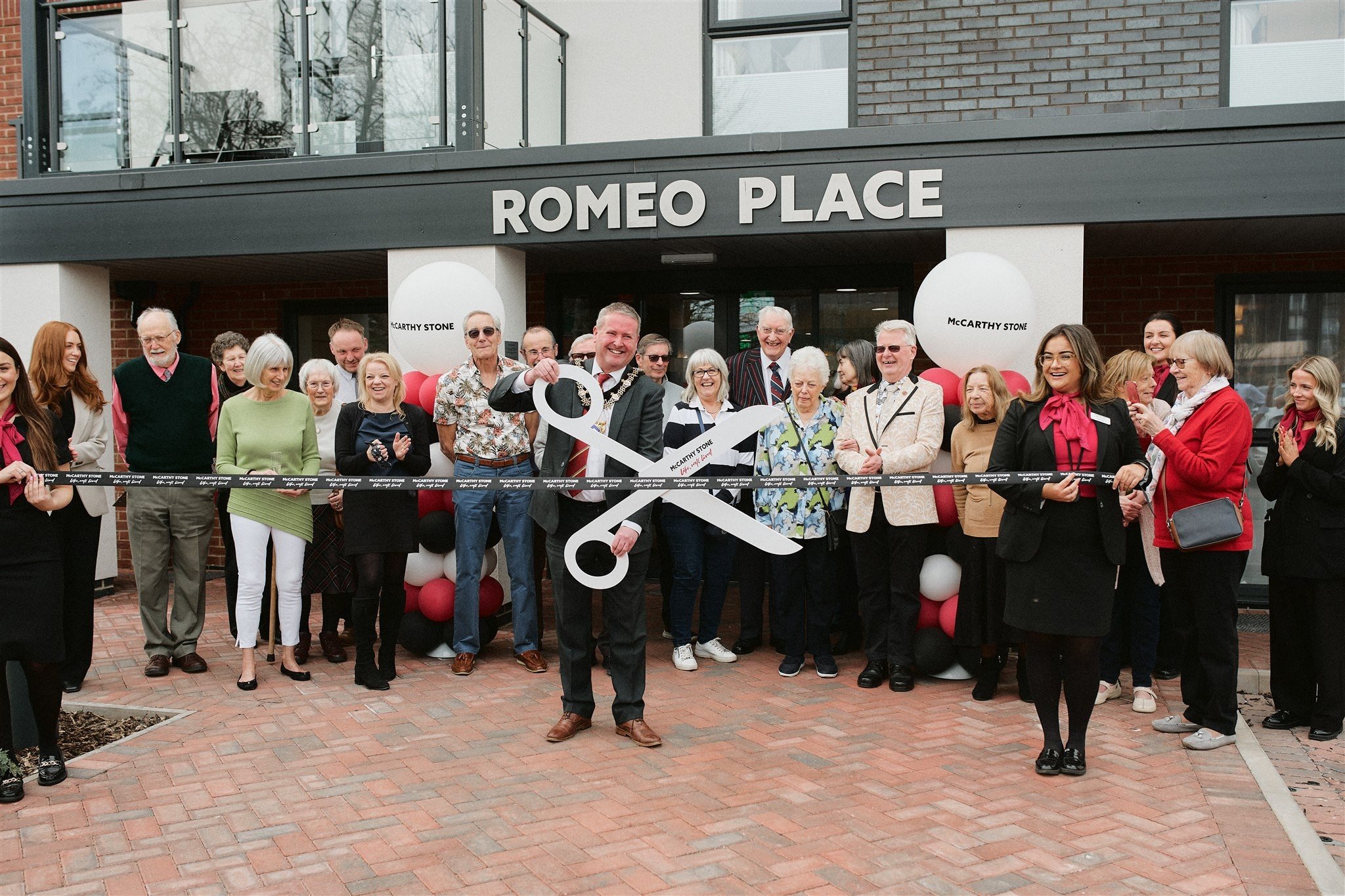 a group of people holding a large black and white kite