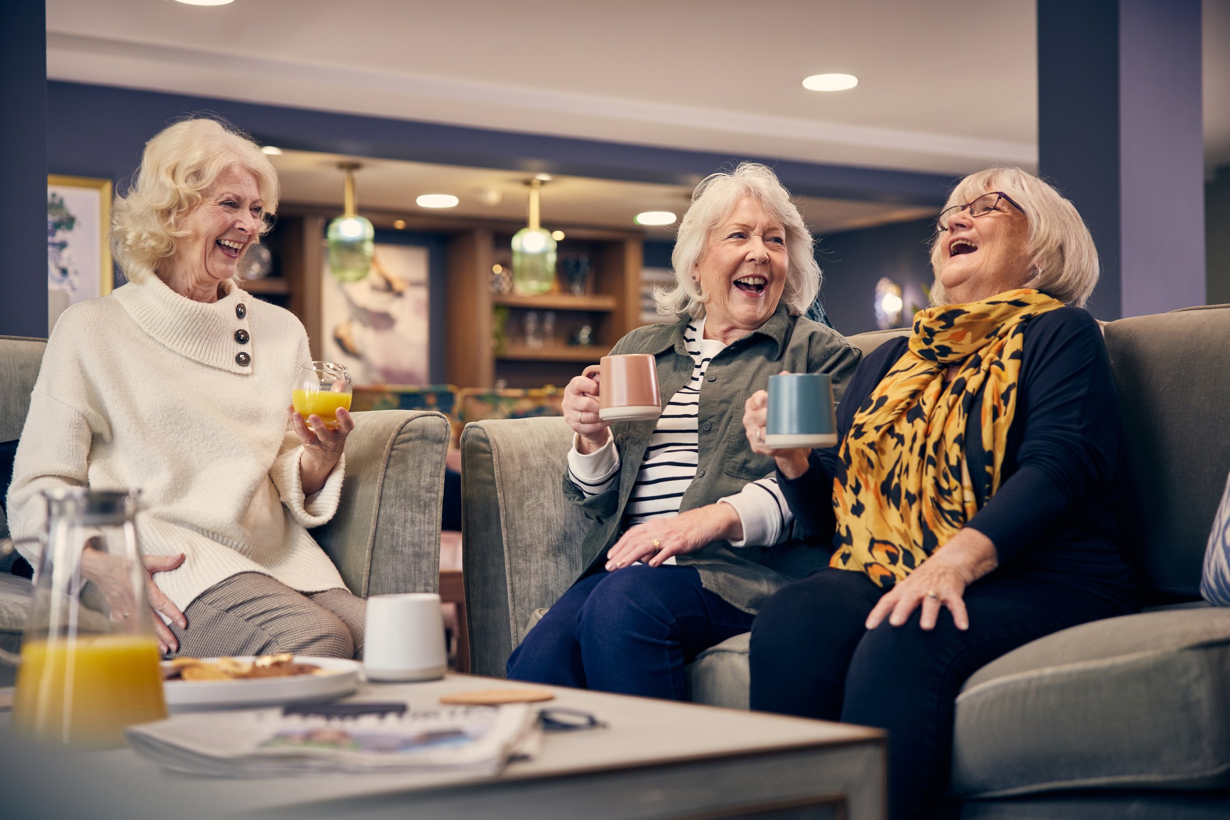 a group of women sitting on a couch and laughing