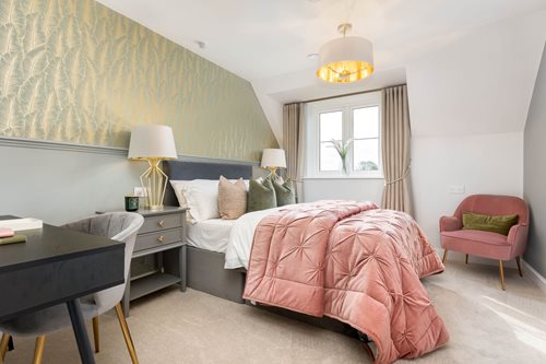 a bedroom with a bed desk and chair