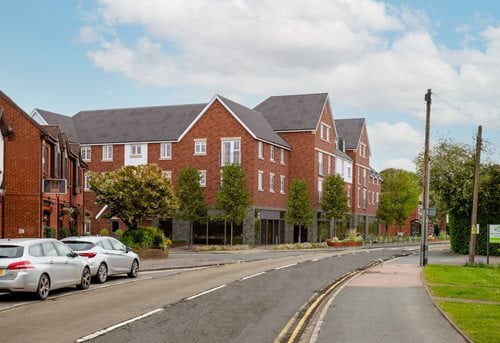 a street with cars parked on the side and a building in the background