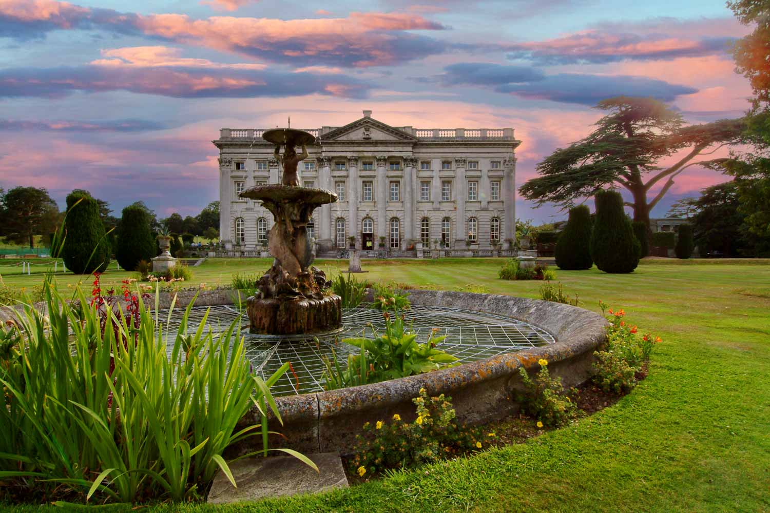 a large white house with a fountain in front of it