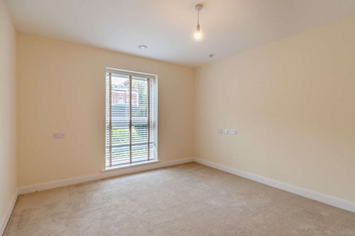 a room with a window and a carpeted floor