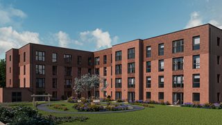 a large brick building with a garden in front of it