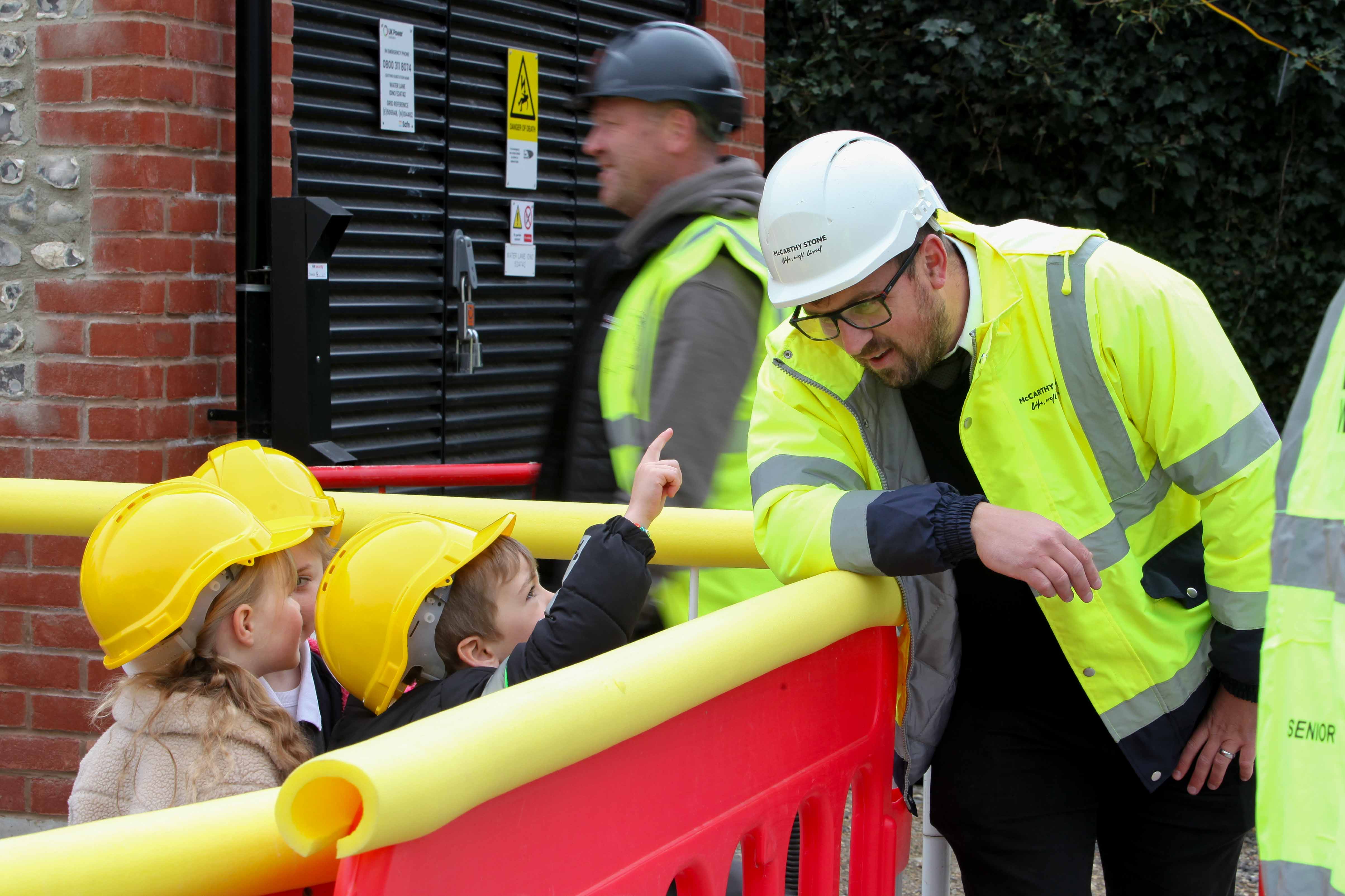 a group of people in safety vests looking at a person in a yellow vest