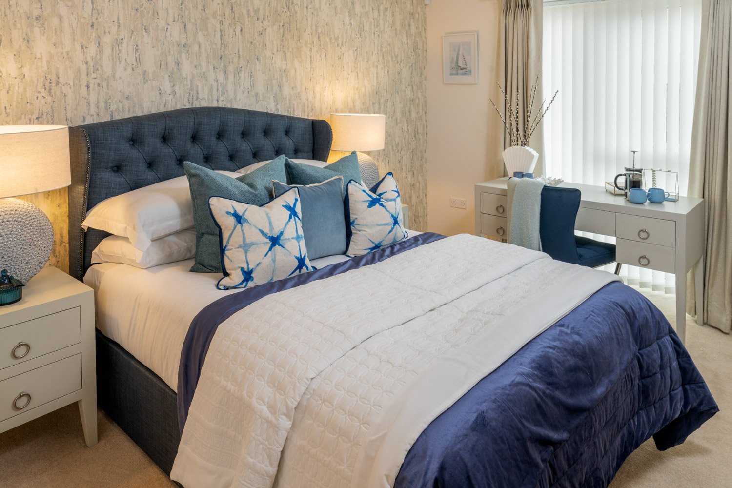 a bed with blue and white pillows