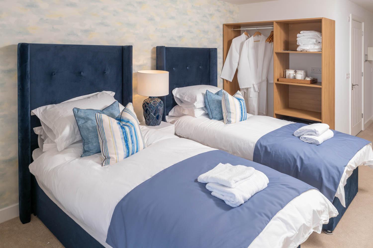 a couple of beds with blue sheets