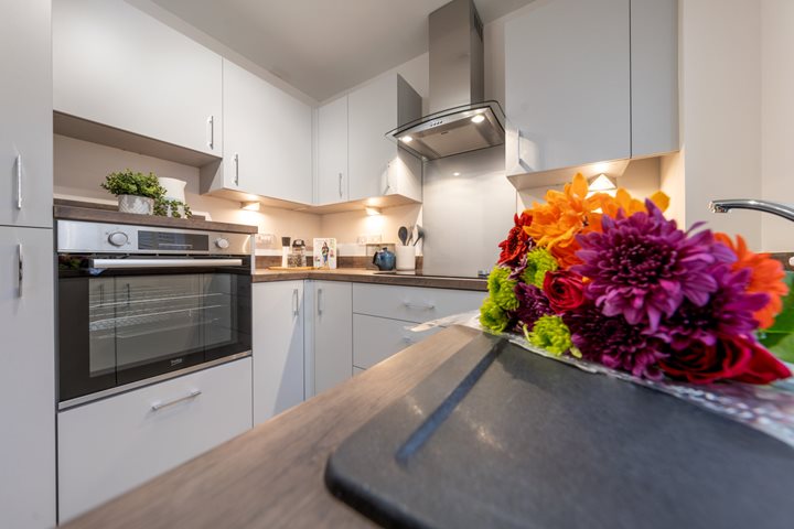 a kitchen with a counter top and flowers on it