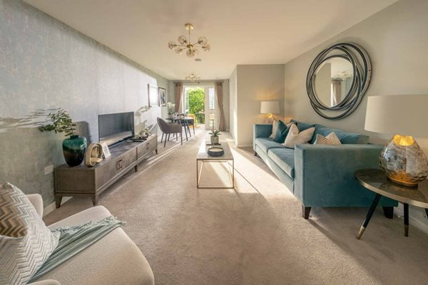a living room with a blue couch and a round mirror