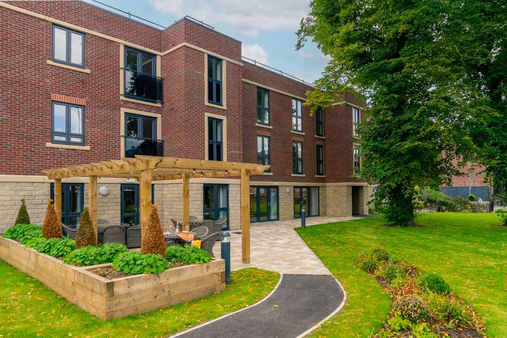 a building with a walkway and a lawn in front