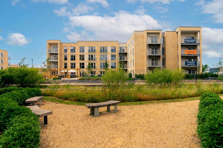 a park with benches and buildings in the background