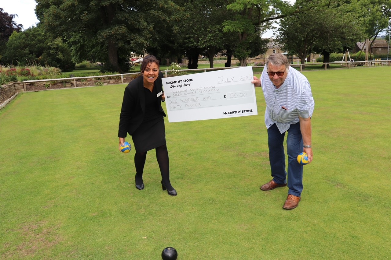a man and woman standing next to a sign on a golf course