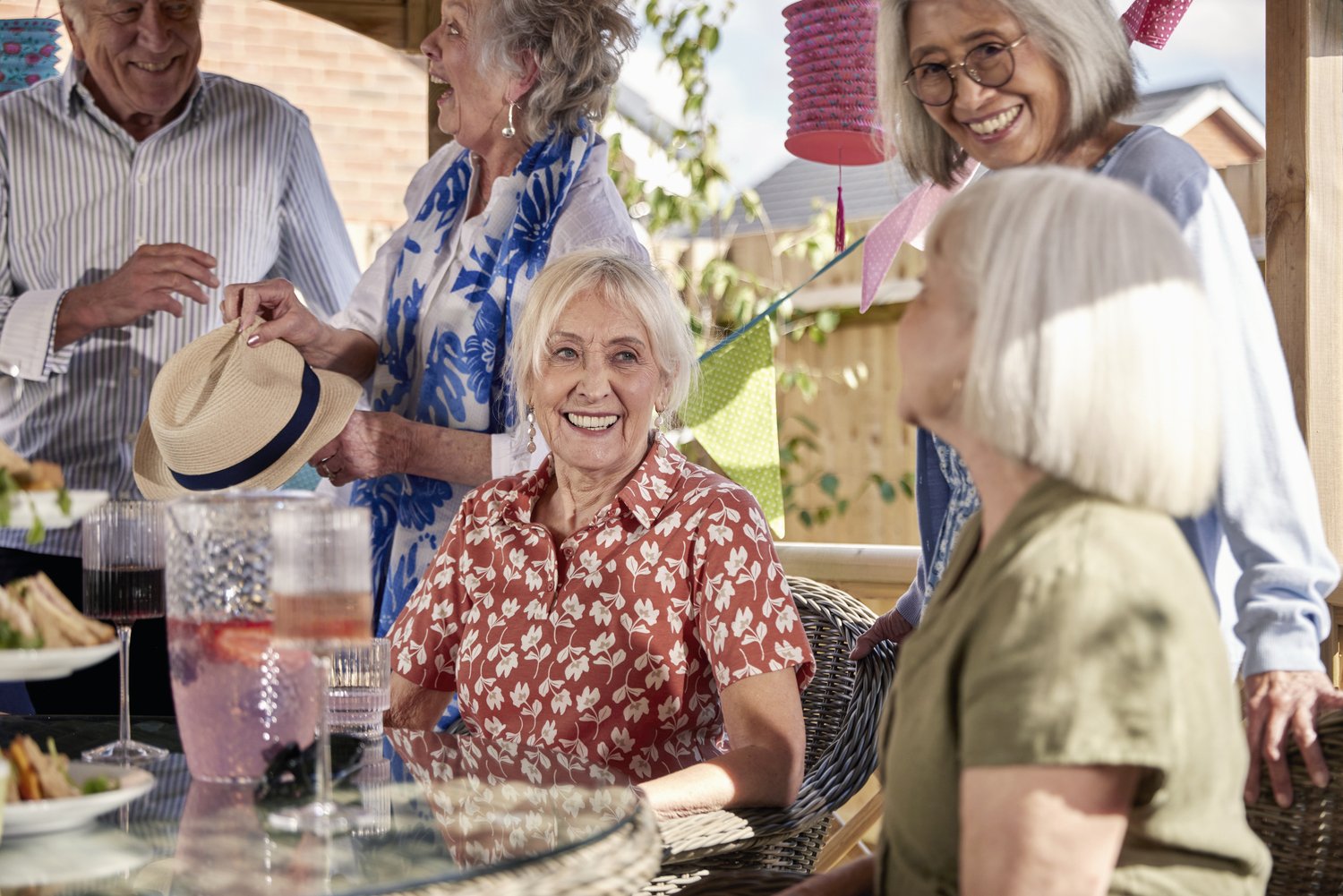 a group of people standing around a table with food