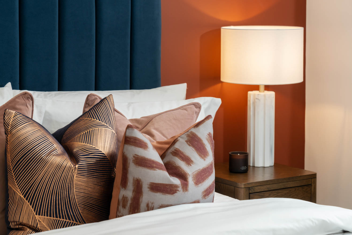 a bed with a lamp and pillows