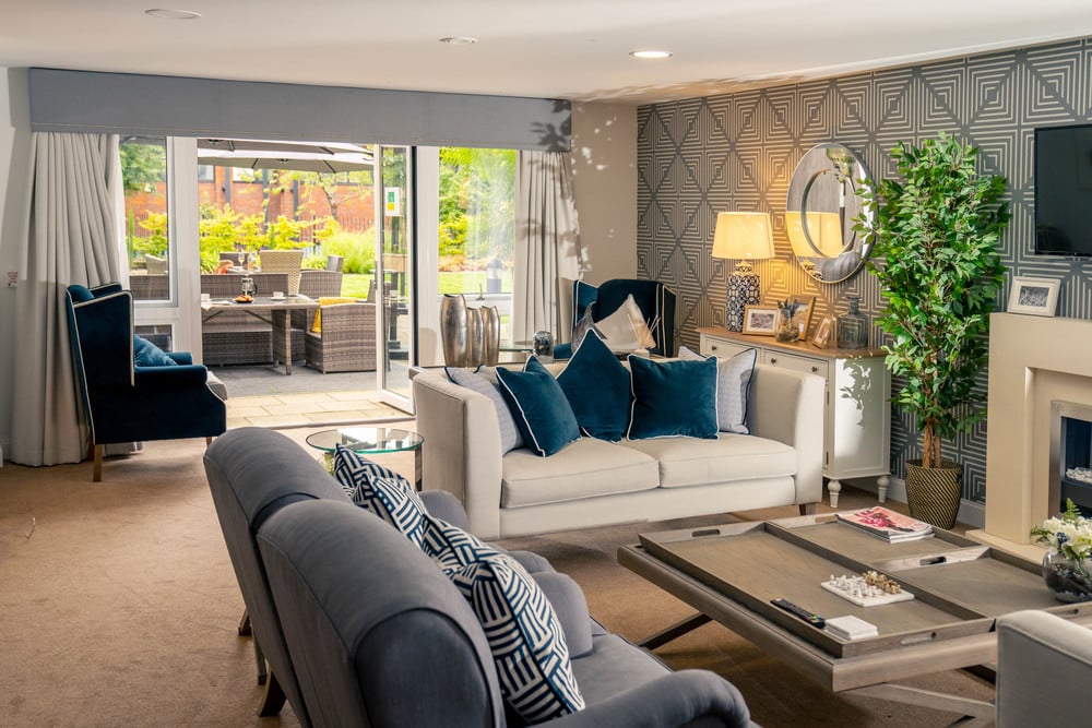 The communal lounge of a McCarthy Stone retirement community, featuring large doors leading to a shared garden. 