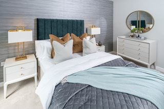 a bed with a mirror on the wall