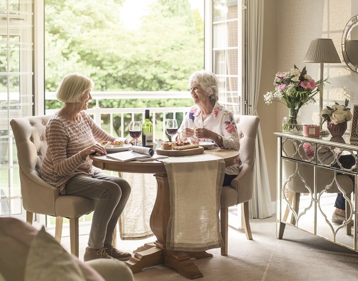 a couple of women sitting at a table eating food