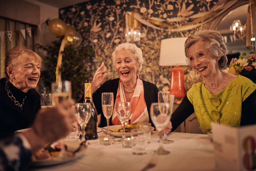 a group of women sitting at a table with wine glasses