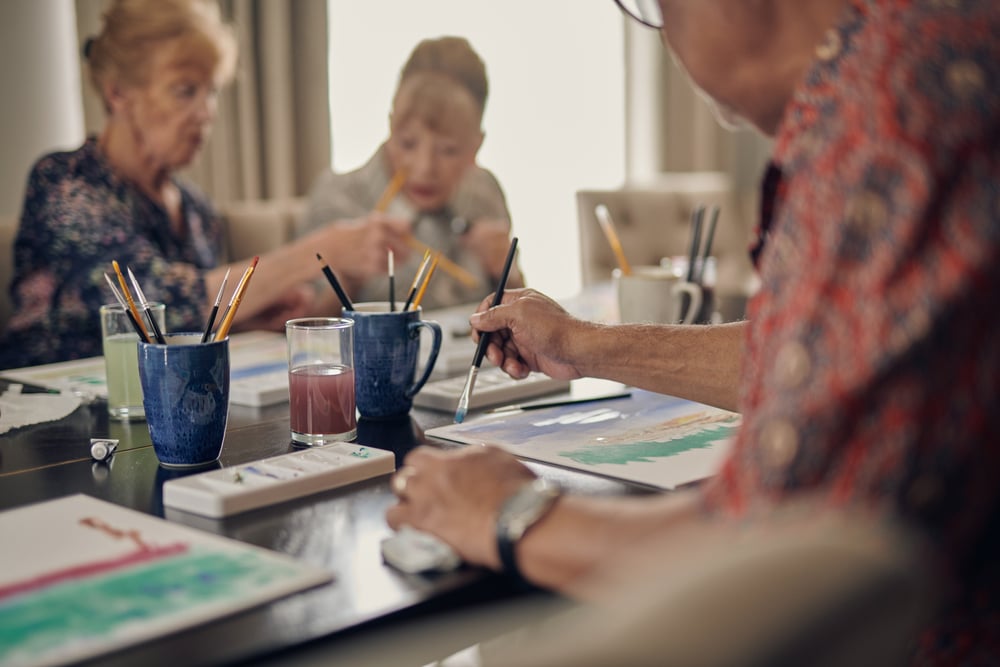 a group of people sitting at a table writing on paper