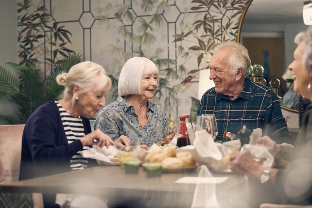 a group of people sitting at a table with food