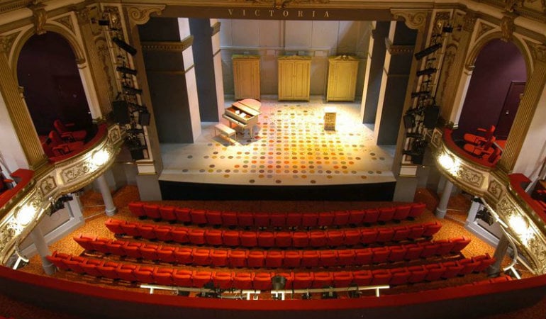 a room with a large stage and a large stage with a group of people in the front