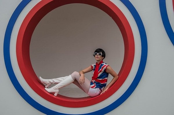 a person in a red and white costume sitting in a circle