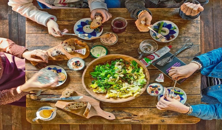 a group of people around a table with food on it