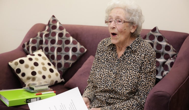 an old woman sitting on a couch