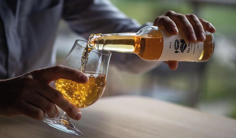 a person pouring a glass of wine