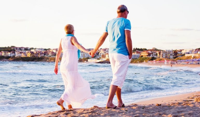 a man and woman holding hands on a beach