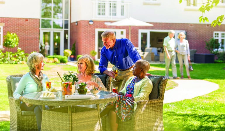 a group of people sitting at a table outside