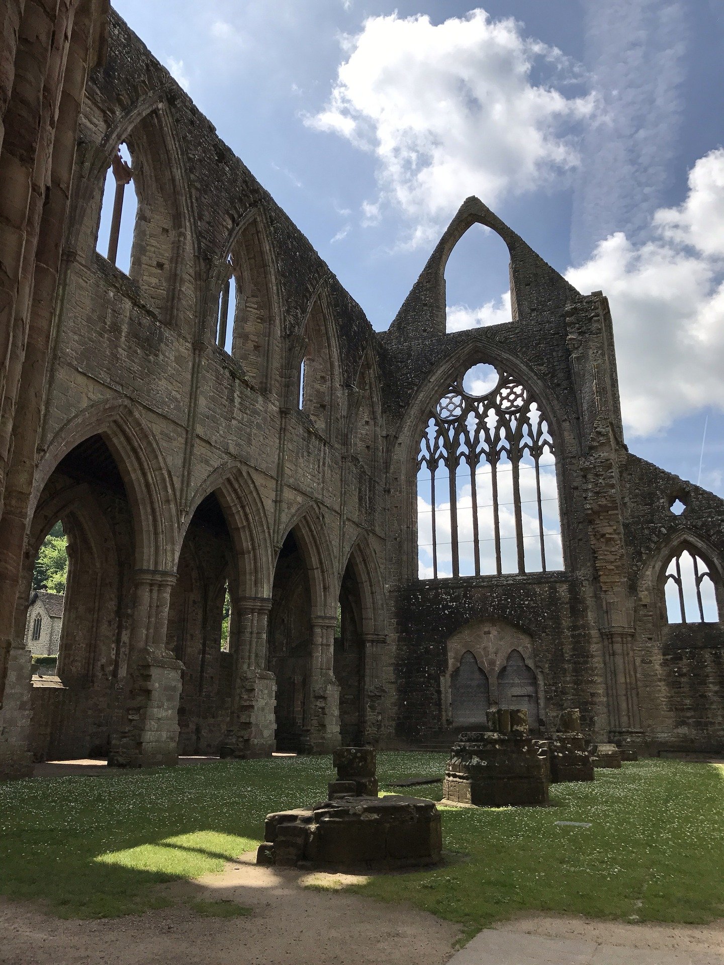 a large stone building with Sweetheart Abbey in the background