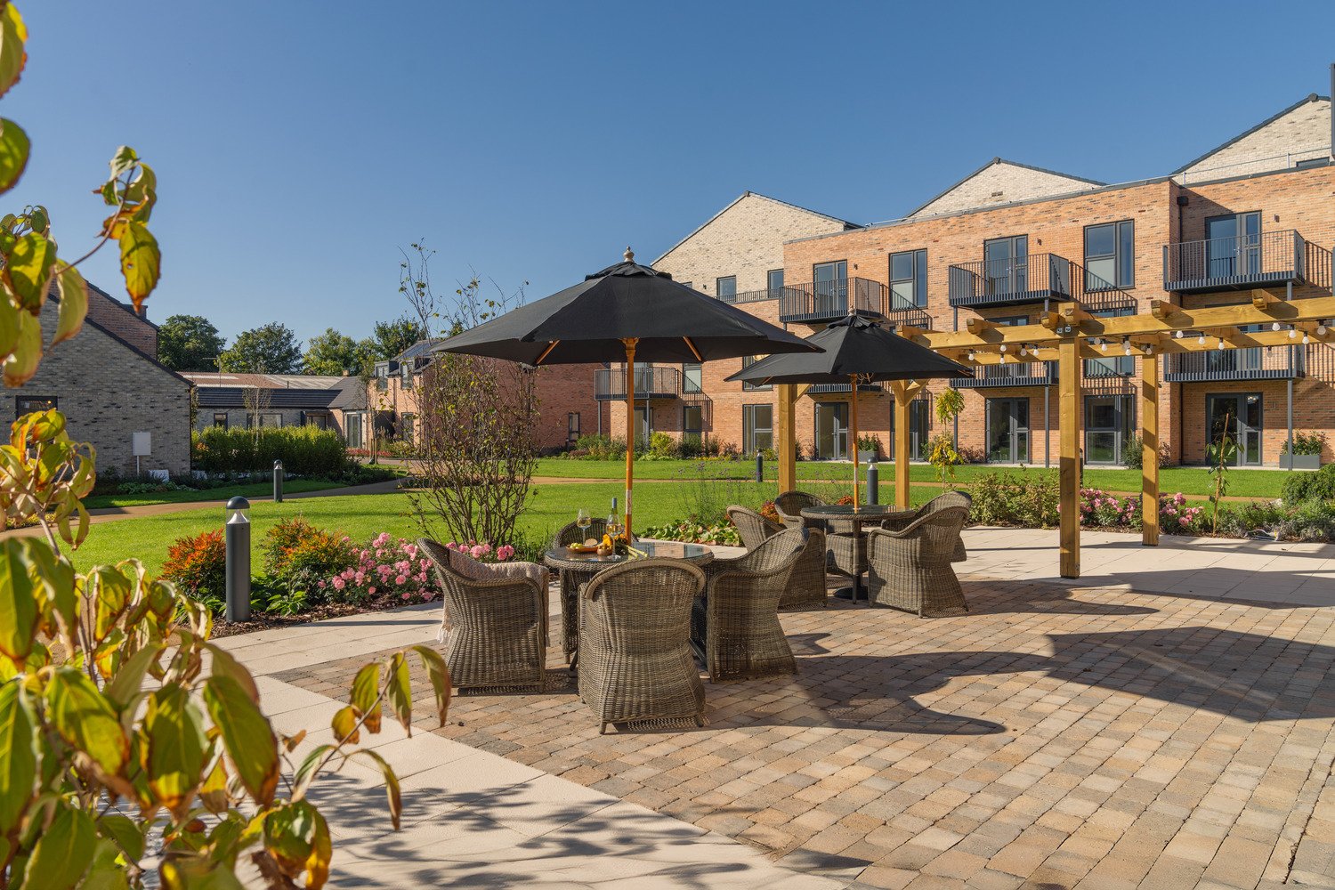 A retirement living development garden with patio and seating area.