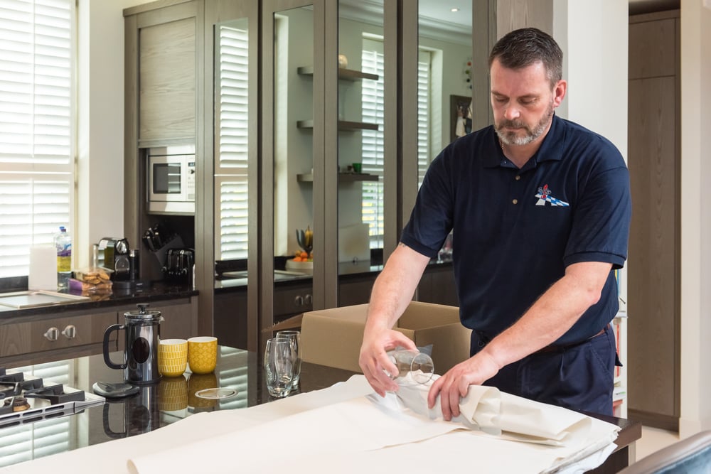 Removal man wraps possessions so senior can move to retirement home with ease.